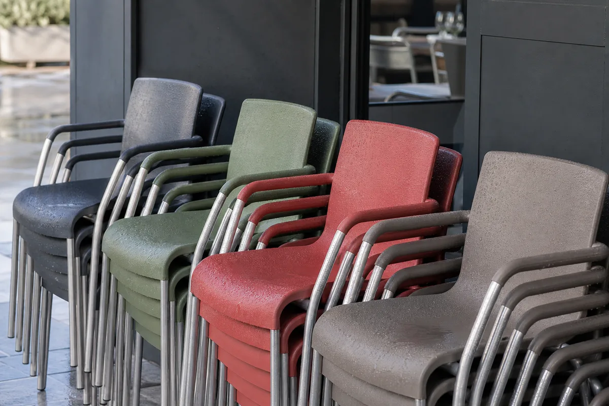 Chaises de terrasse en aluminium et polypropylène alignées devant la façade d’un restaurant